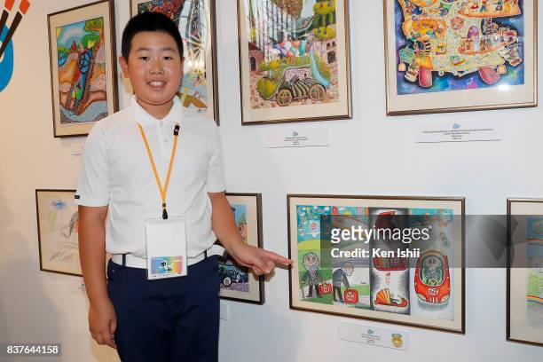 Hong Yu Liang of Canada, gold award winner of age 8 to 11 category for 'The Suitcase Car', stands next to his artwork during the 11th Toyota Dream...