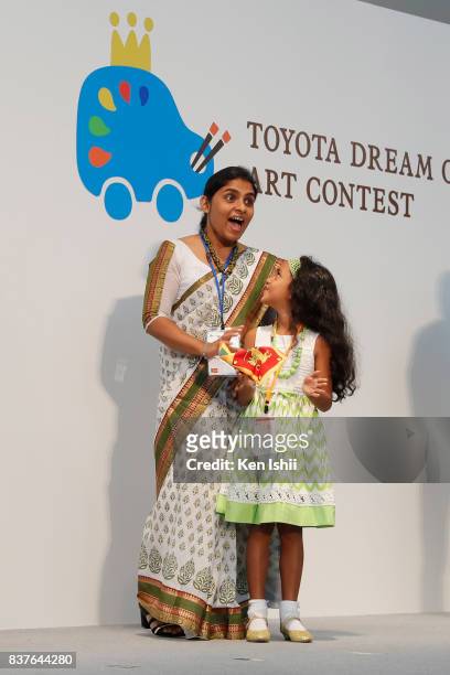Ruwindya Thushadi Indraratne of Sri Lanka, gold award winner of age 7 and under category for 'Toyota Knowledge Paradise Car', reacts with her mother...