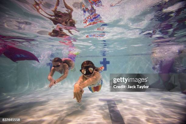 Mermaiding students swim in their tails during a Mayim Mermaid Academy lesson at the swimming pool at Bournemouth Collegiate School on August 19,...