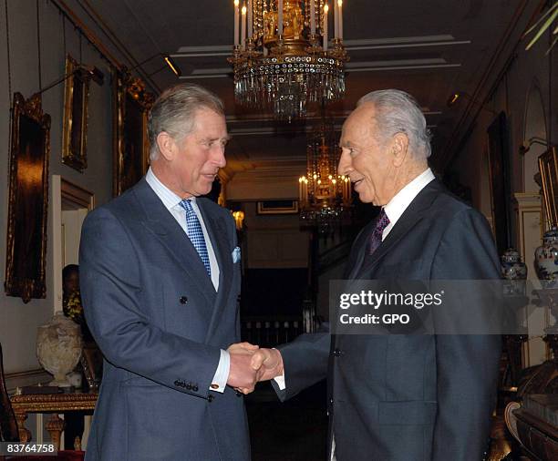 In this handout image provided by Israeli Government Press Office, Israeli President Shimon Peres shakes hands with Prince Charles, Prince of Wales...