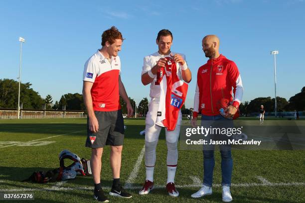 Gary Rohan and Jarrad McVeigh of the Sydney Swans present Kaeller Chryst of Stanford University with a Swans jersey during a US College Football...