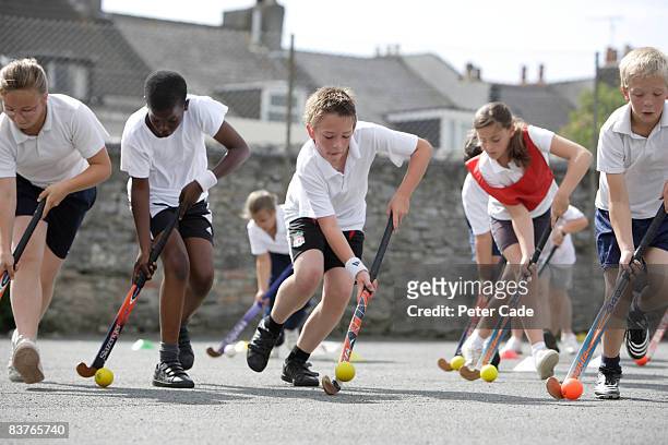 school children playing hockey - female hockey player stock pictures, royalty-free photos & images