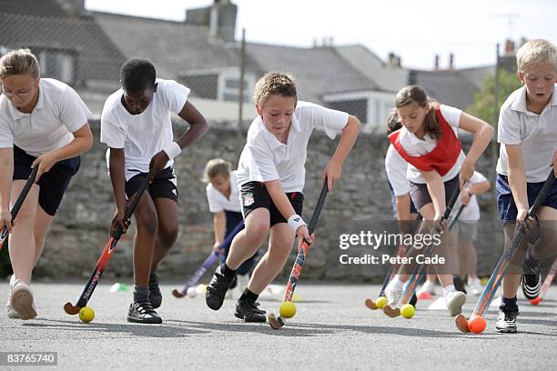 school children playing hockey - elementary age - fotografias e filmes do acervo