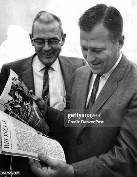 Rivals Review Broncos Hal Rogers and Bill Dauer, Kansas City Chamber of Commerce executives, look over a Denver Broncos story in a pro football...