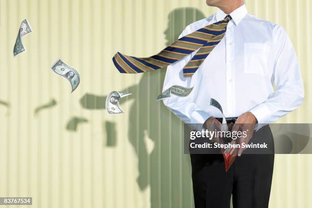 business man with money flying out of his wallet - loss stock pictures, royalty-free photos & images