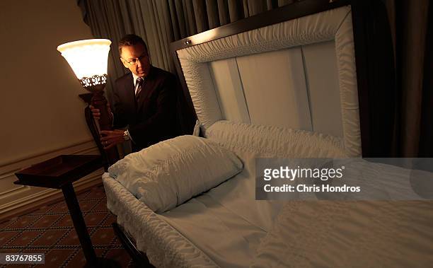 Funeral director Peter DeLuca, owner of Greenwich Village Funeral Home looks over a casket in his funeral parlor on November 20, 2008 in New York...