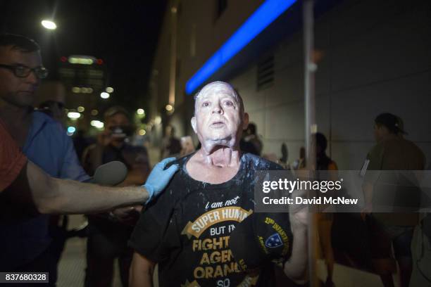 People console a man who was pepper sprayed by police after a rally by President Donald Trump at the Phoenix Convention Center on August 22, 2017 in...