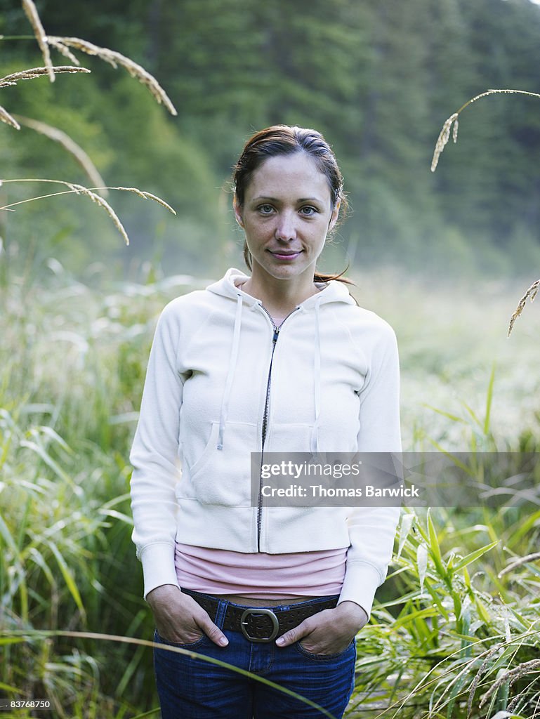 Portrait of woman standing in field, dawn