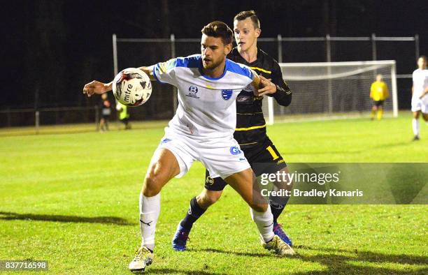 Sam Smith Gold Coast City is pressured by the defence of Stephen Green of Moreton Bay during the FFA Cup round of 16 match between Moreton Bay United...