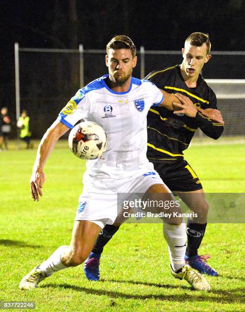 Sam Smith Gold Coast City is pressured by the defence of Stephen Green of Moreton Bay during the FFA Cup round of 16 match between Moreton Bay United...