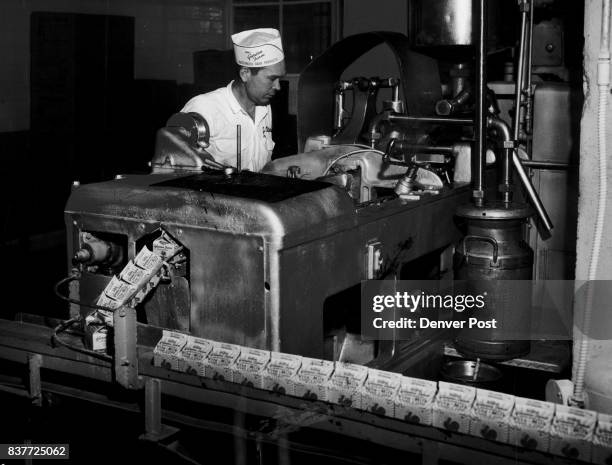 Half-pint containers of milk roll off the assembly line at the Garden Farm Dairy, E. 60th Ave. And Albion St., as John Peters of Derby, operator,...