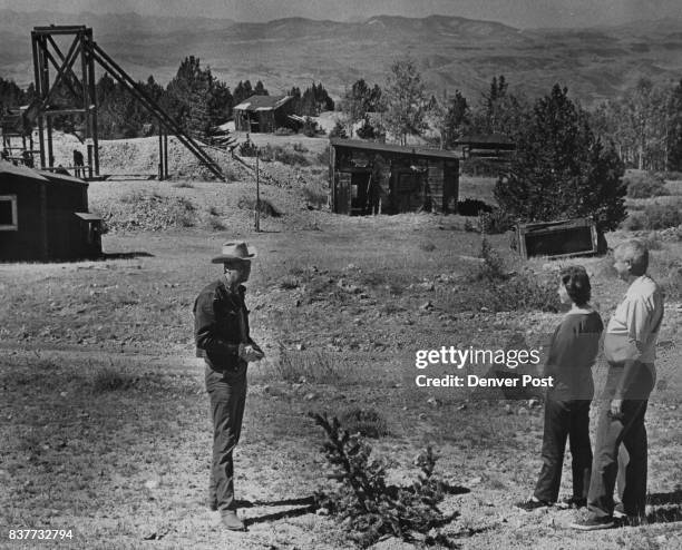 Harold Hern, left, Cripple Creek businessman, guides Mr. And Mrs. Howard Humphries of Colorado Springs through ghost town of Windy City. Free tours...