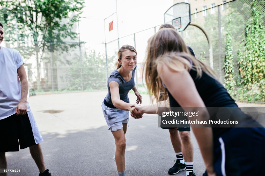Athletes Shaking Hands Before Friendly Game Of Basketball Outdoors