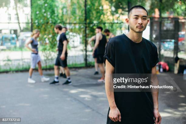 stylish young athlete, ready for basketball game with friends - persona in secondo piano foto e immagini stock