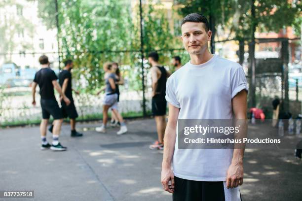 young athlete at basketball court with friends - t-shirt stock-fotos und bilder