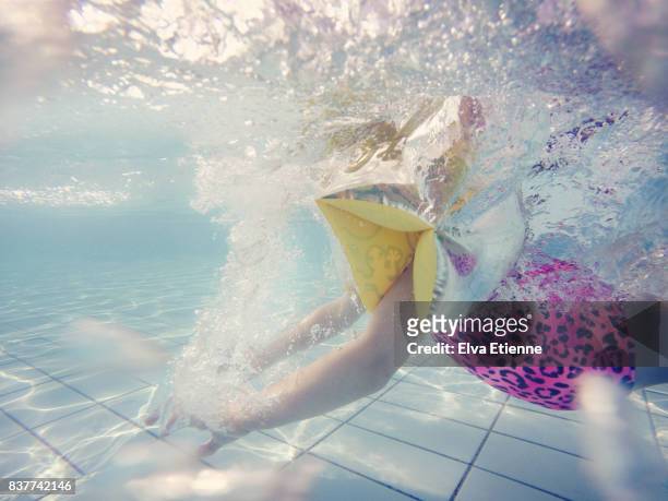 underwater image of a young girl learning to swim - ウマグ ストックフォトと画像