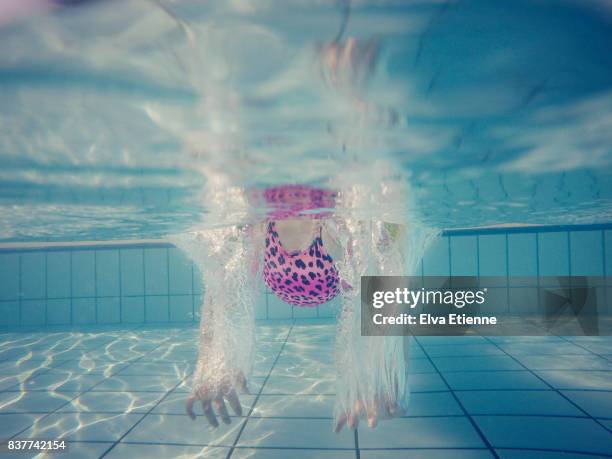 underwater image of young girl swimming in a pool - ウマグ ストックフォトと画像