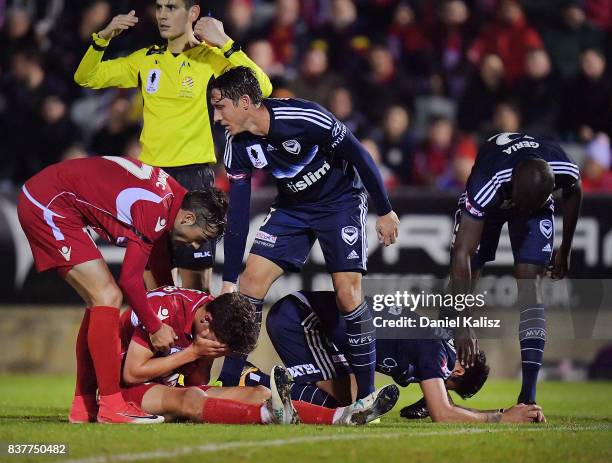 George Blackwood of United and Rhys Williams of the Victory react after colliding during the round of 16 FFA Cup match between Adelaide United and...