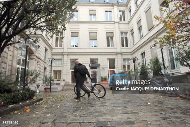 Man walks with his bike in front of the socialist headquarters in Paris, on November 21, 2008. Former presidential candidate Segolene Royal headed...