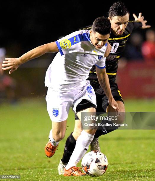 Riley Dillon Gold Coast City attempts to break away from the defence of Alex Janovsky of Moreton Bay during the FFA Cup round of 16 match between...