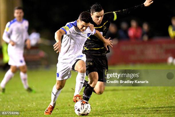 Riley Dillon Gold Coast City attempts to break away from the defence of Alex Janovsky of Moreton Bay during the FFA Cup round of 16 match between...