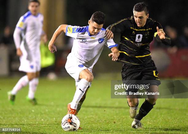 Riley Dillon Gold Coast City attempts to break away from the defence of Alex Janovsky of Moreton Bay during the FFA Cup round of 16 match between...