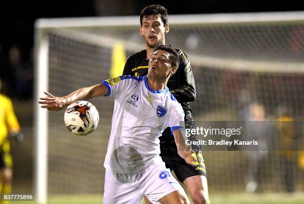 Riley Dillon of Gold Coast City is pressured by the defence of Corey Lucas of Moreton Bay during the FFA Cup round of 16 match between Moreton Bay...