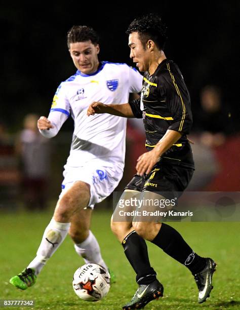 Kyusub Bang of Moreton Bay is challenged by Roman Hofmann of Gold Coast City during the FFA Cup round of 16 match between Moreton Bay United and Gold...