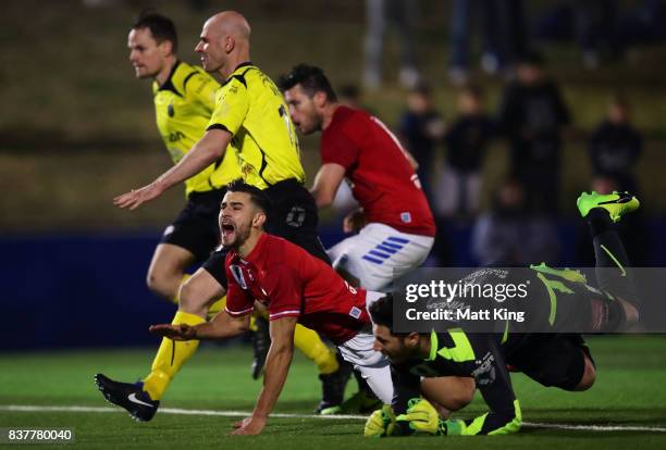 Michael Neill of Sydney United 58 FC collides with Heidleberg United goalkeeper Christopher Theodoridis-Petropoulos during the FFA Cup round of 16...