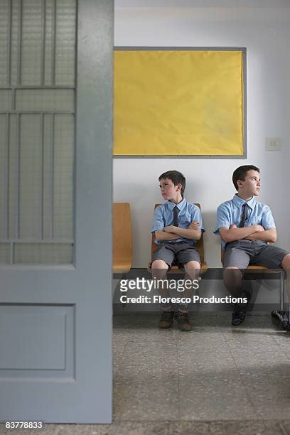 school boys sitting outside office - school punishment photos et images de collection