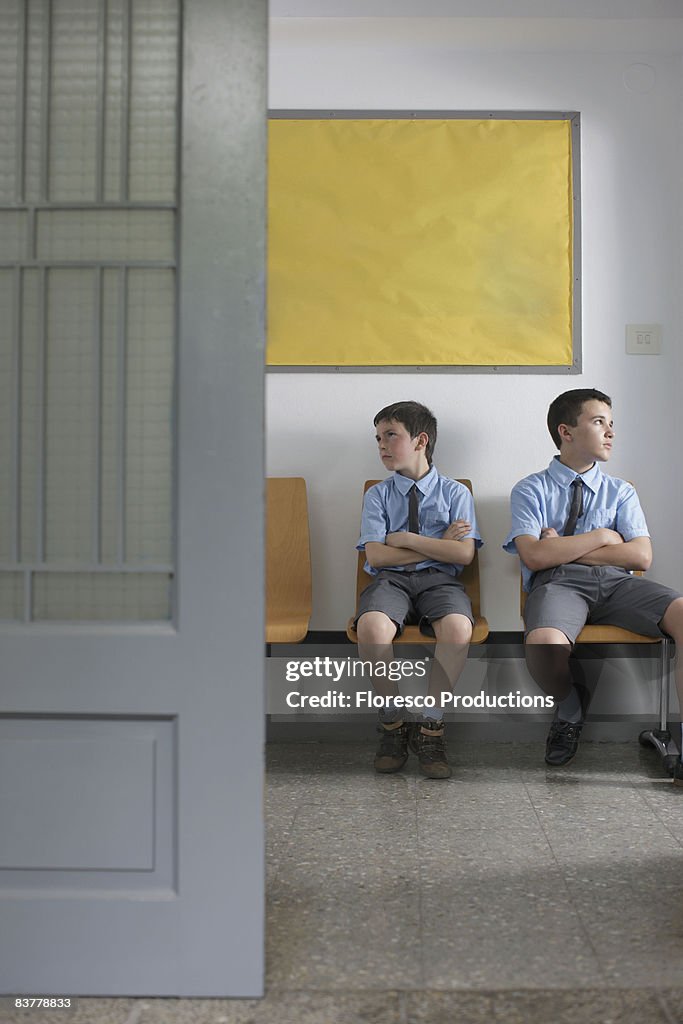 School boys sitting outside office