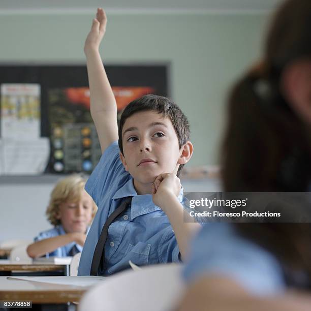 school boy raising hand in class - answering stock pictures, royalty-free photos & images