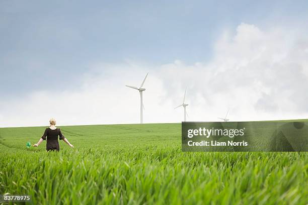pregnant woman walking through wind farm - the whirligig stockfoto's en -beelden