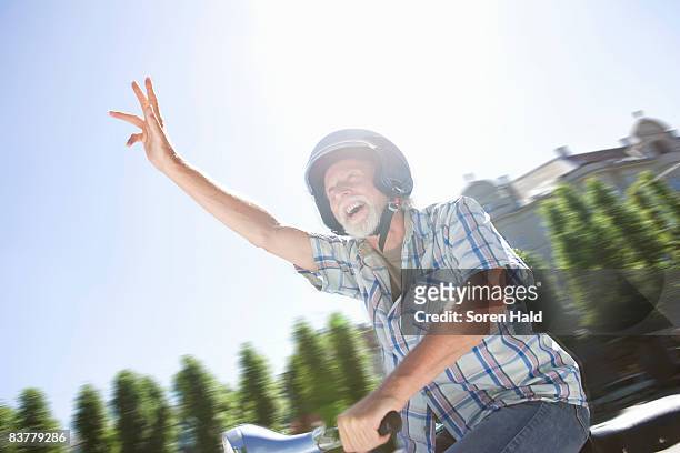 man on scooter, waving - man with scooter bildbanksfoton och bilder