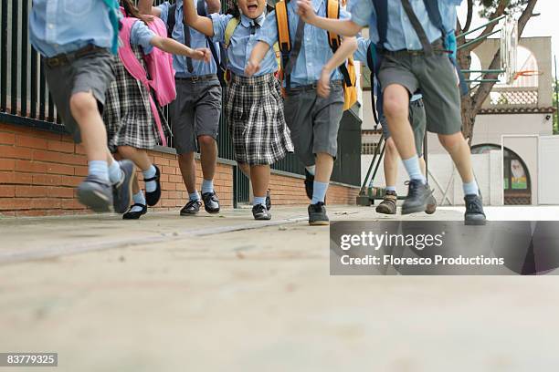 school children running low angle - uniform stockfoto's en -beelden