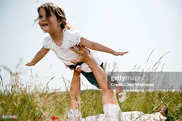 girl held aloft flying - learning generation parent child photos et images de collection