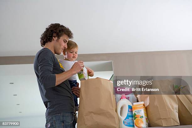 father and baby with grocery bags - baby bag stock-fotos und bilder