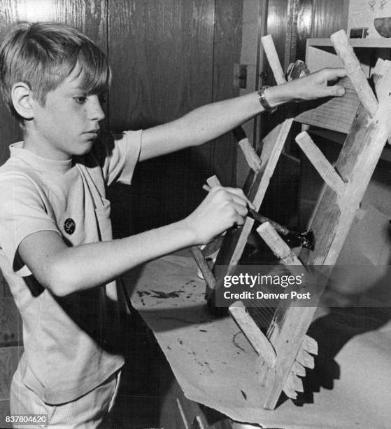 Stuart Tom of 55 Jasmine St., paints a gun rack and hat hanger in the woodworking shop at the Graland Country Day School summer session. The...