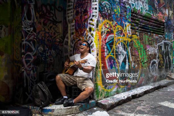 Melbourne, Australia, 21 march 2017. A man sing out loud with his guitar in a tiny street of the central business district. Melbourne is ranked as...