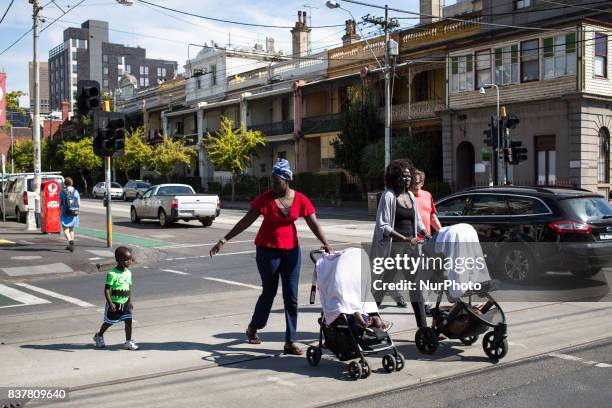 Melbourne, Australia, 20 march 2017. Two refugees walk their child in the street of fitzroy. Melbourne is ranked as the worlds most liveable city for...