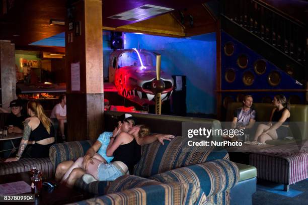 Melbourne, Australia, 19 march 2017. A couple kiss on couch in a popular bar of the Fitzroy district. Melbourne is ranked as the worlds most liveable...