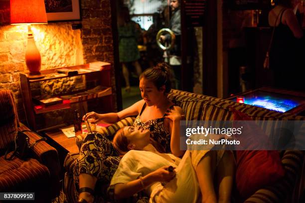 Melbourne, Australia, 18 march 2017. Two young women drink cocktails on the couch of local bar of the Fitzroy district. Melbourne is ranked as the...