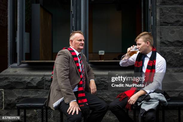 Melbourne, Australia, 25 march 2017. Two Australian football supporters drink a beer in a bar of the central business district. Melbourne is ranked...