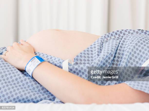 pregnant belly in hospital gown - hospital gown imagens e fotografias de stock