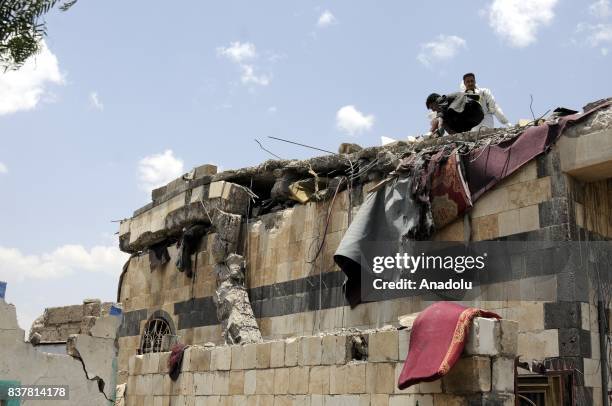 People search for survivors and death bodies at a heavily damaged building after Saudi-led coalition's air strikes over Arhab District of Sanaa,...