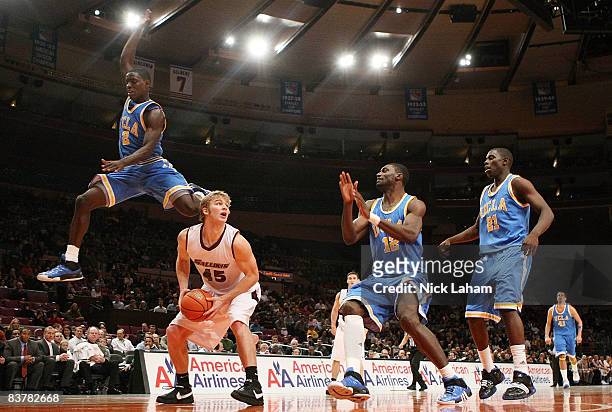 Darren Collison of the UCLA Bruins jumps over Carlton Fay of the Southern Illinois Salukis on November 21, 2008 at Madison Square Garden in New York...