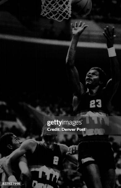 Special Transmission to The Denver Post - T.R. Dunn of the Nuggets lofts a shot to the basket while Alex English of the Nuggets and George Gervin of...