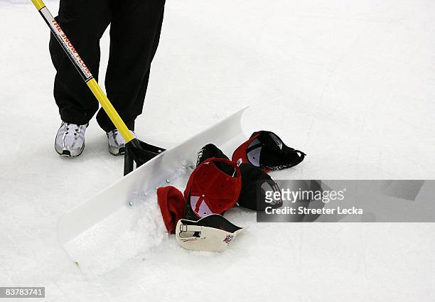 Man cleans up hats thrown on the ice after Eric Staal of the Carolina Hurricanes scored his third goal making it a hat trick on the night against the...