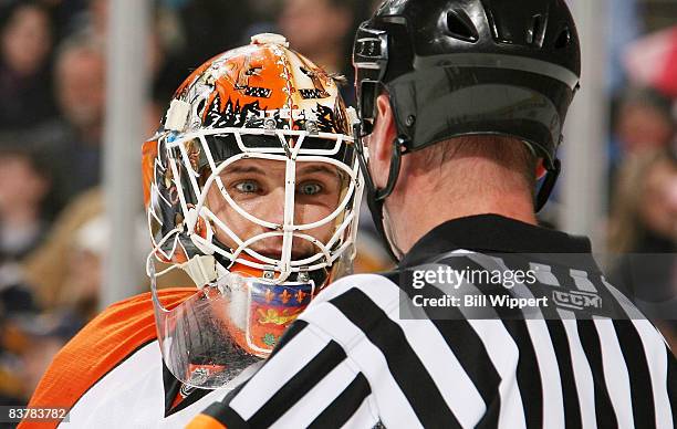 Martin Biron of the Philadelphia Flyers talks with Referee Kevin Pollock during the game against the Buffalo Sabres on November 21, 2008 at HSBC...