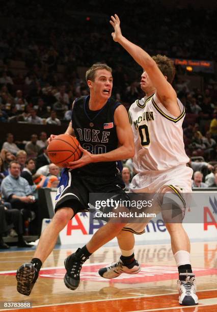 Jon Scheyer of the Duke Blue Devils goes to the basket against Zack Novak of the Michigan Wolverines on November 21, 2008 at Madison Square Garden in...